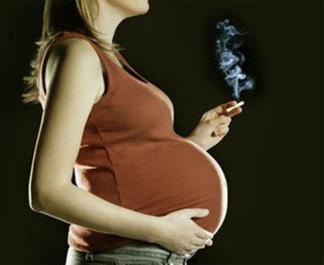 Pregnant woman smoking a cigarette.