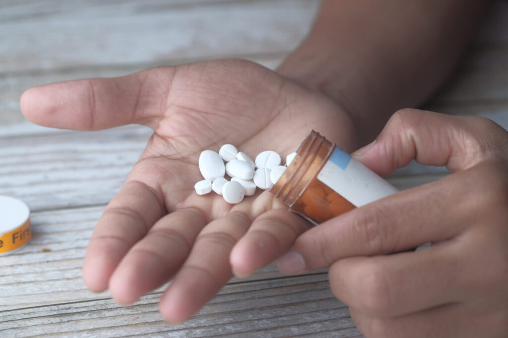 Man taking more sleeping pills. opioid and drug abuse concept