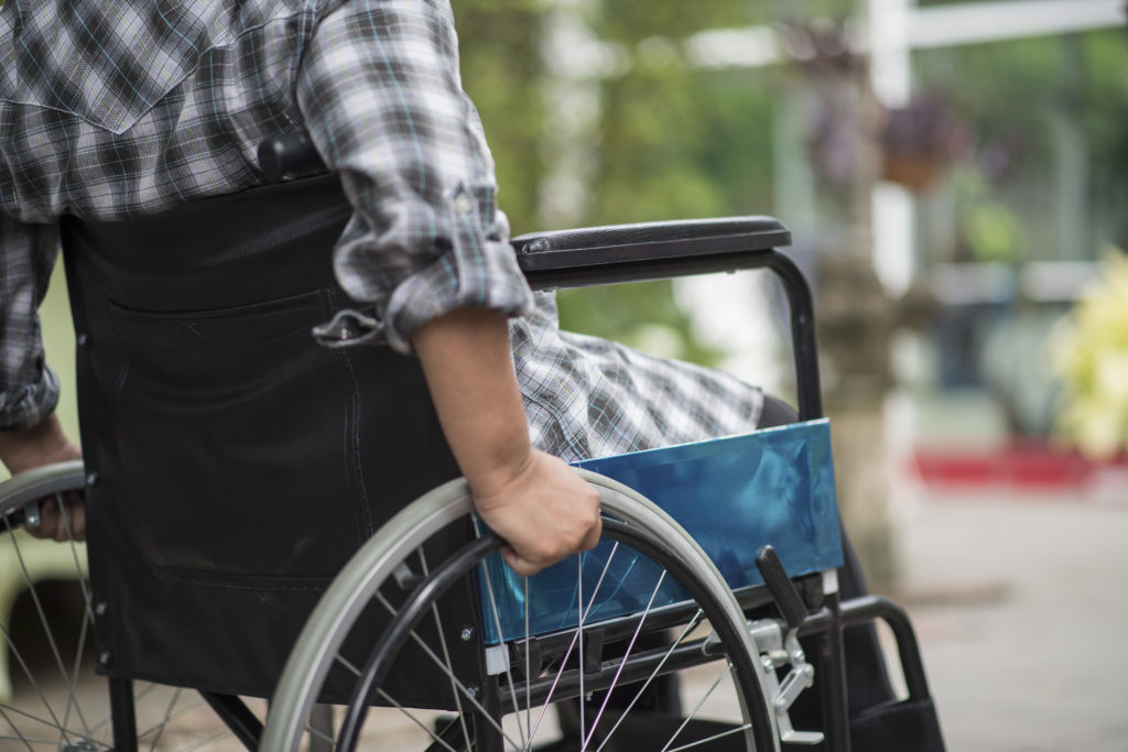 woman with her hand on wheel of wheelchair