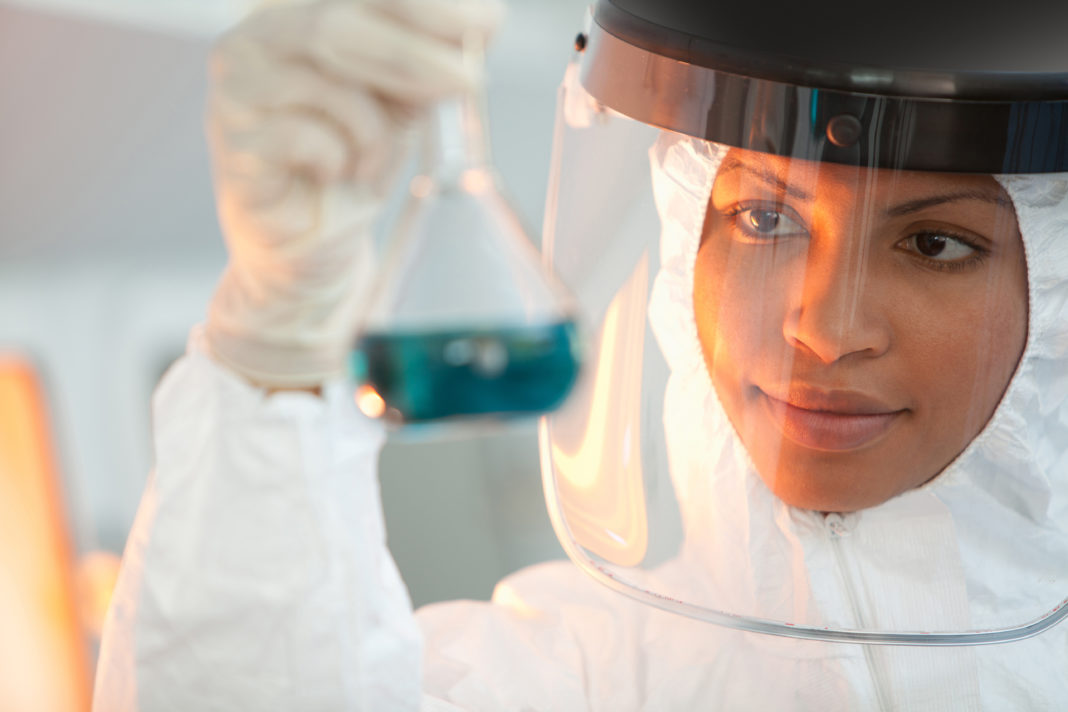 Scientist examining beakers in lab