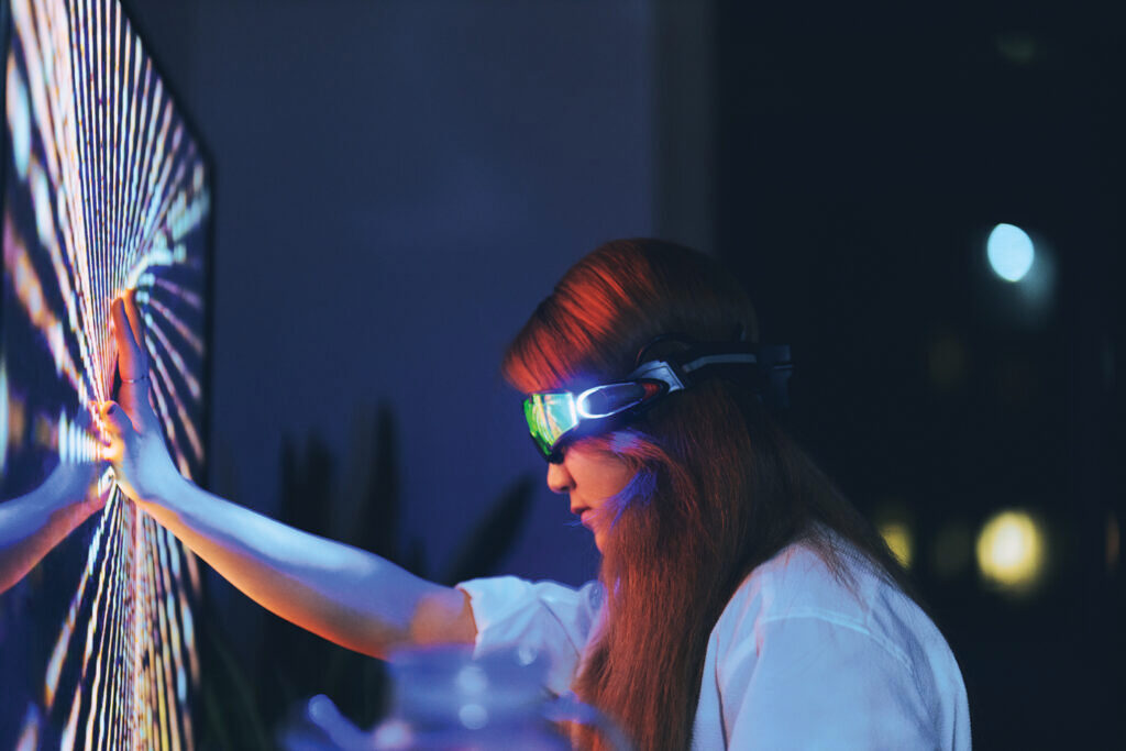 Young woman wearing augmented reality glasses touching screen with hands