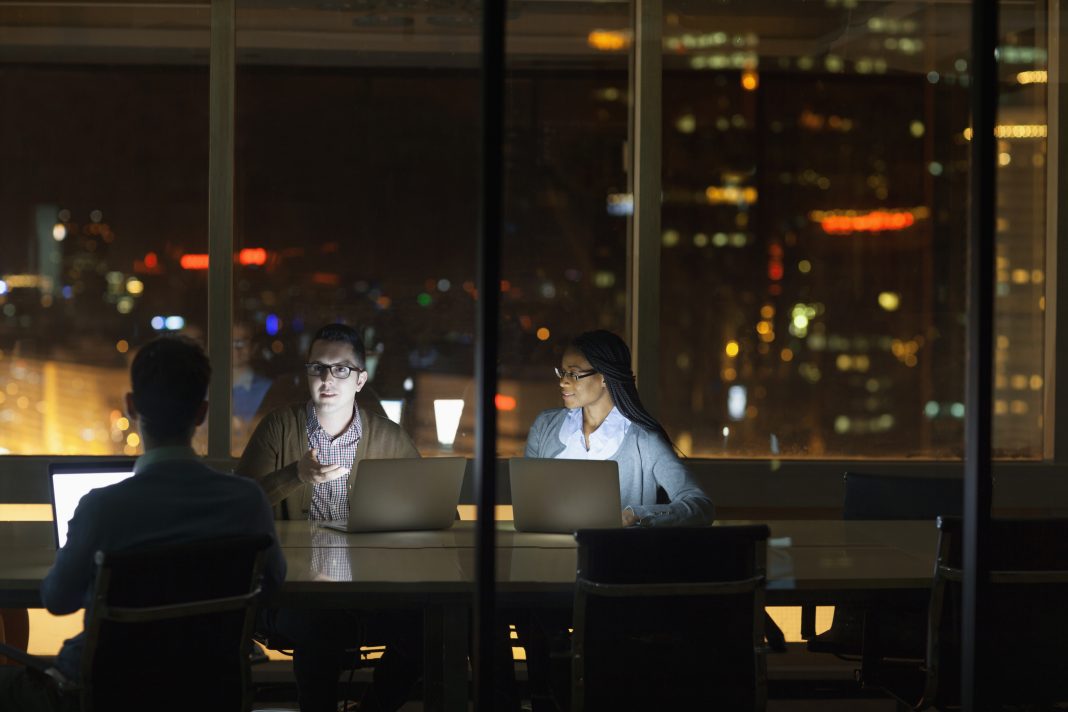 Colleagues collaborating in office at night