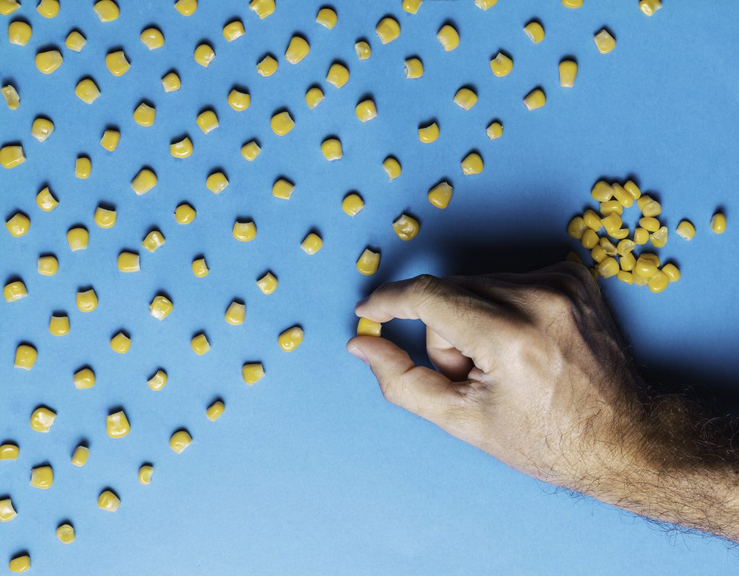 Man with obsessive compulsive disorder placing corn kernels neatly in a row