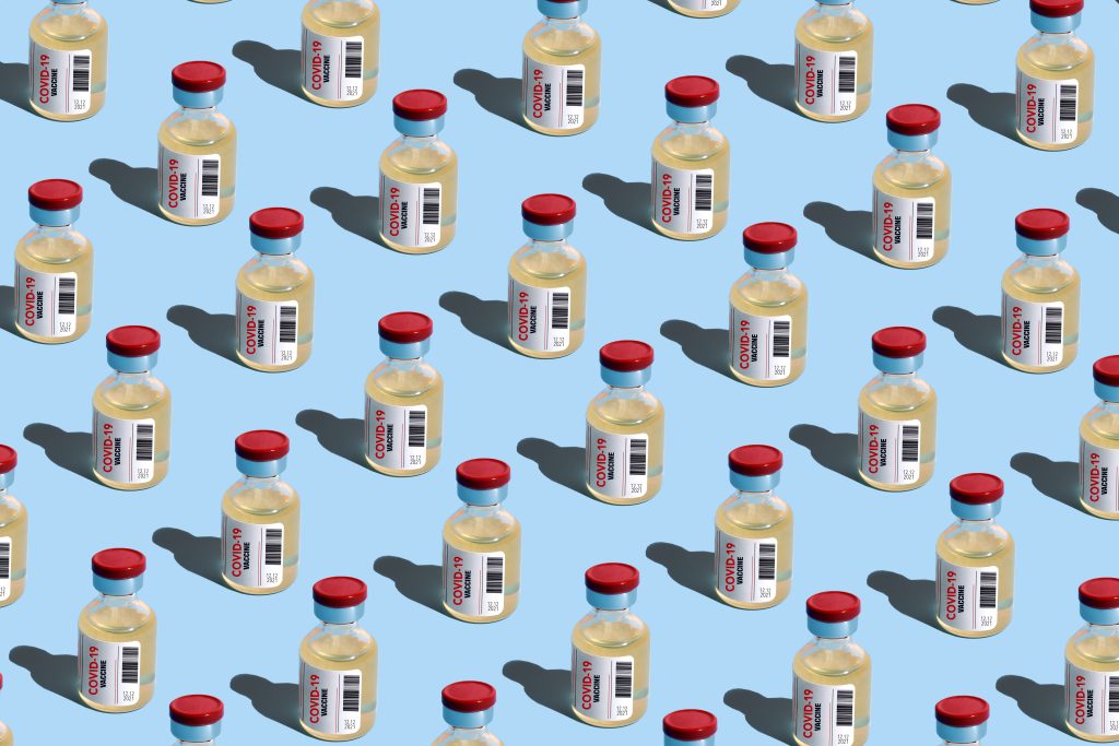 Repeated vials with covid-19 vaccine on the blue background