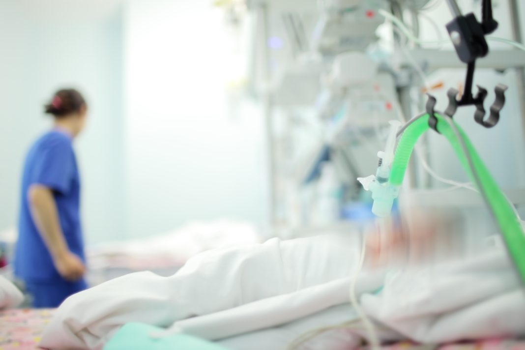 Female medical worker on the baby's bedside in the NICU, unfocused background