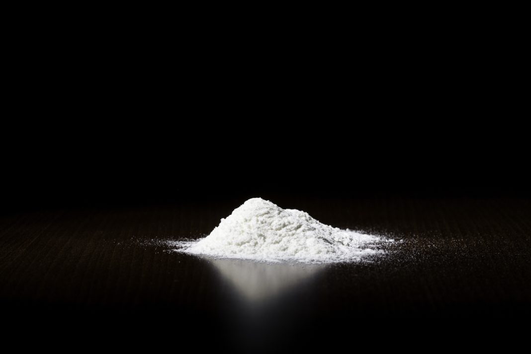 A small pile of white powder on a dark surface