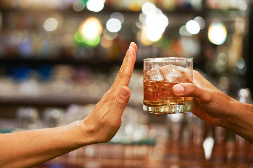 Hand pushing away an alocholic drink