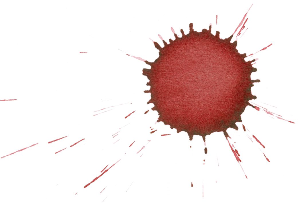 Isolated red ink splatter drop close-up