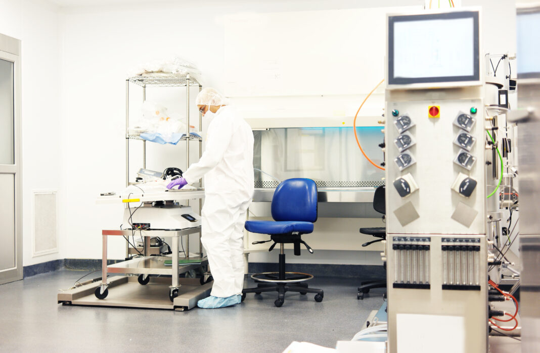 Scientist working in a clean room for cell culture