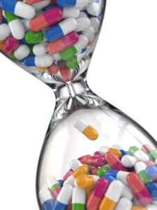 Time of medicine. Pills in hourglass