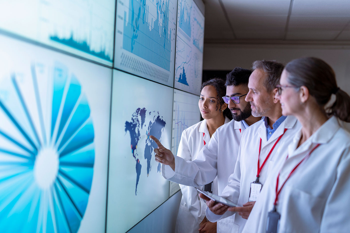 UK, York, Team of researchers inspecting charts on interactive screens