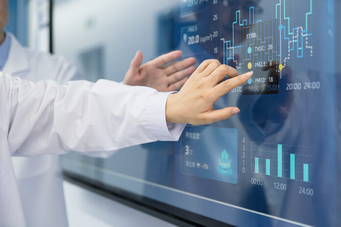 Scientists analyze experimental results on laboratory display screens.
