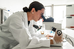 Researcher looking into microscope