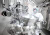 Advancing Microbial-Derived Biologics from Scale-Up to Commercial Production Woman in a proper safety equipment seen in a pharmaceutical manufacturing