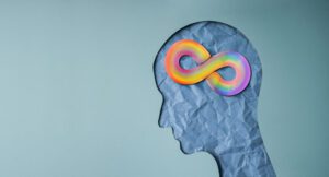 A World Autism Day Concept is represented by a Rainbow Infinity Symbol on the Brain