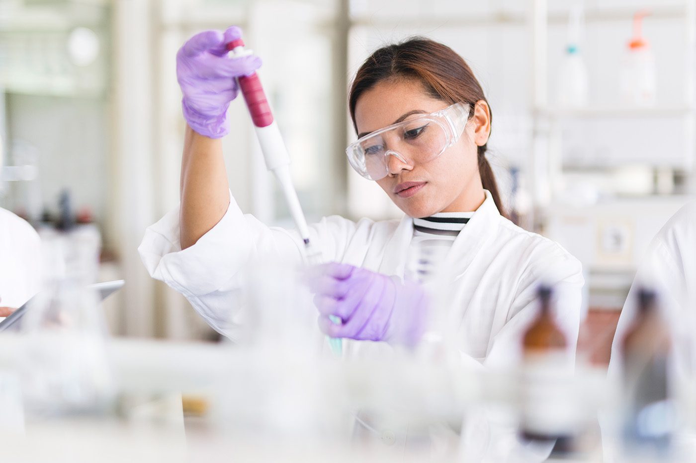 Getty_695234246_FemaleScientistsPipetting_1400 Scientist pipetting