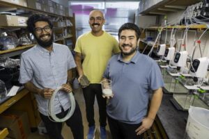 (Left to right) Amogh Jalihal, Neil Dalvie, and team member Mohammed Hijaz carry out research in the rockweathering lab that they equipped with multiple rock-seawater bioreactors to pursue their rockweathering study. [Wyss Institute at Harvard University]
