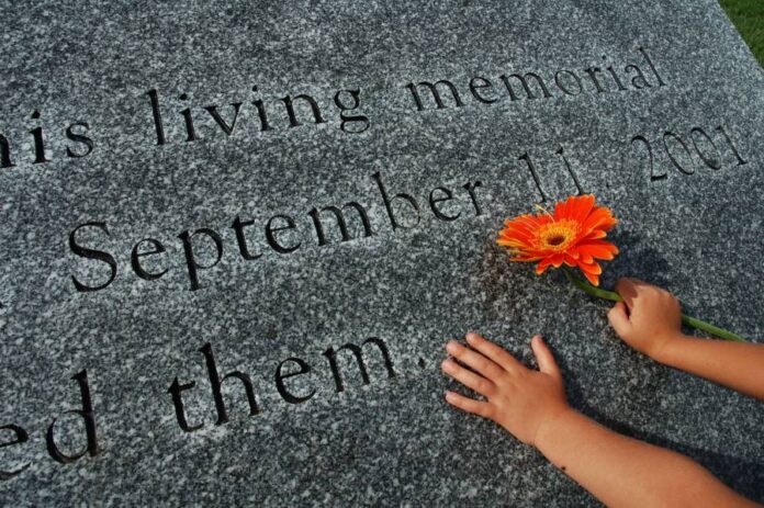 9-11-26-GettyImages-90809975 An image showing a child's hands on a memorial for the September 11, 2001 attacks