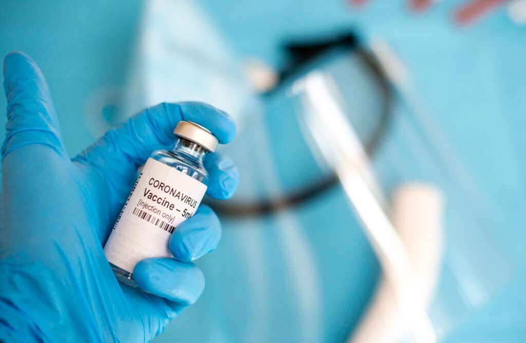 A doctor's hand with a syringe of covid-19 coronavirus vaccine.